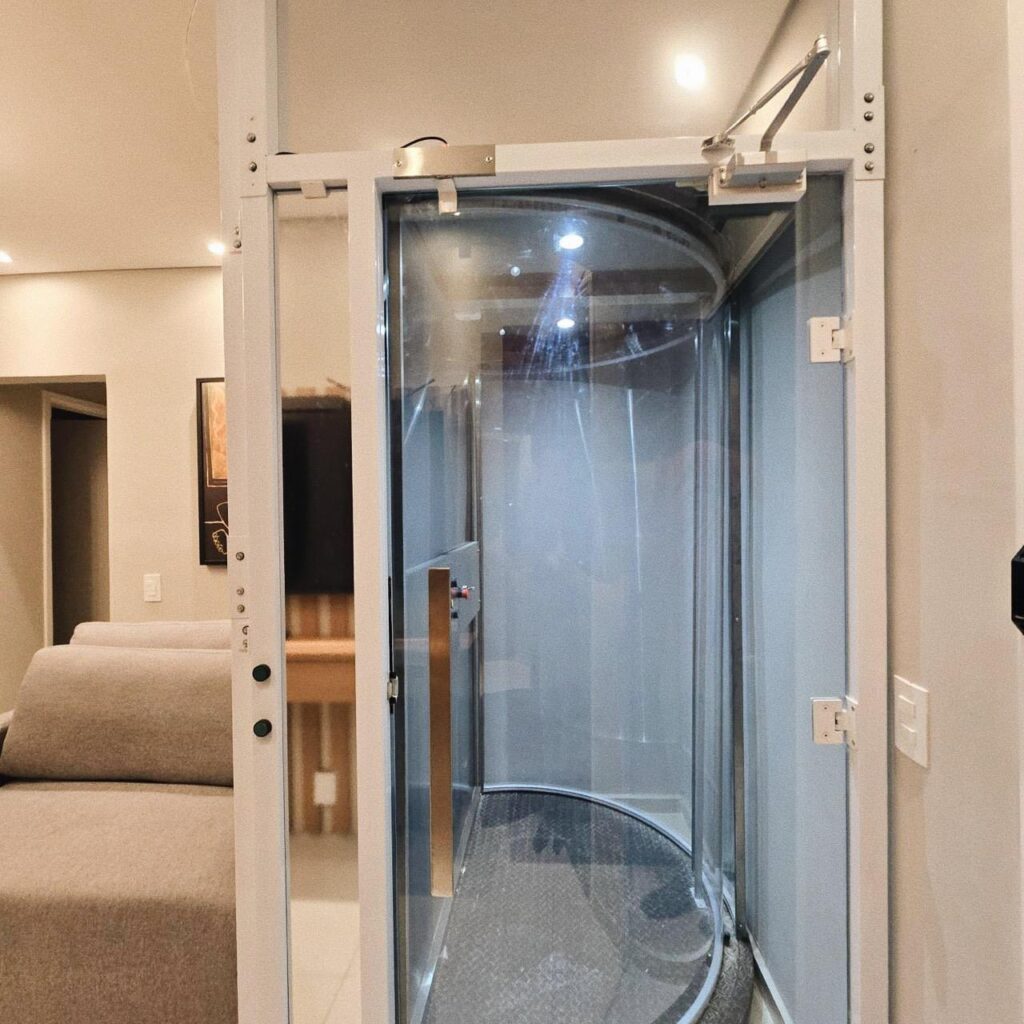 Elevador residencial Tonela de cabine cilíndrica em vidro, ao lado da sala