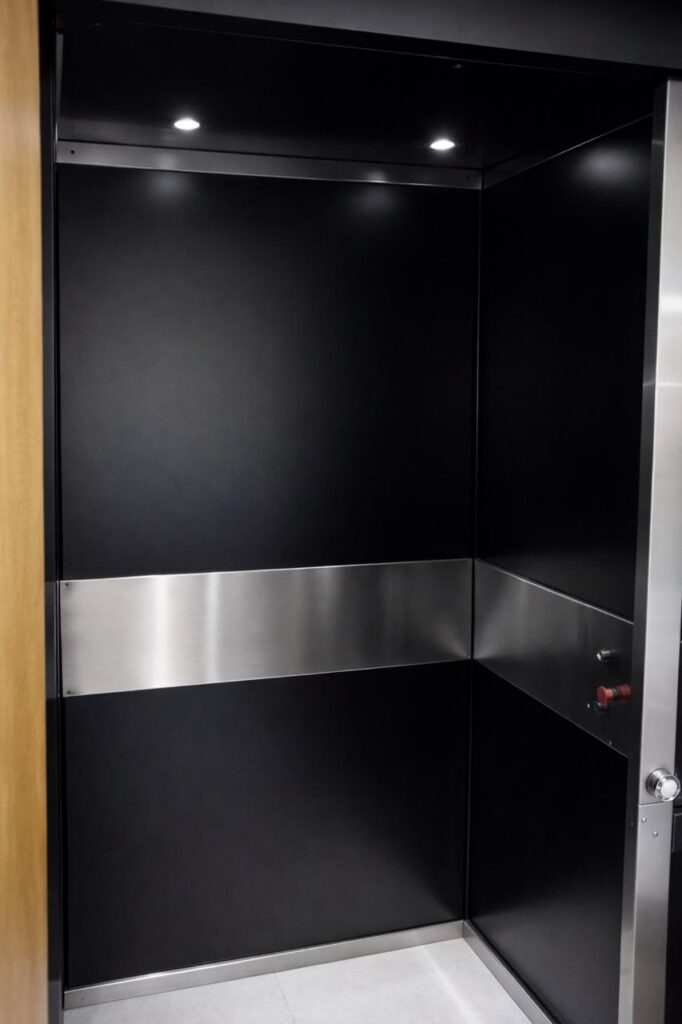 Cabine de elevador Tonela em preto com faixa de inox e iluminação embutida